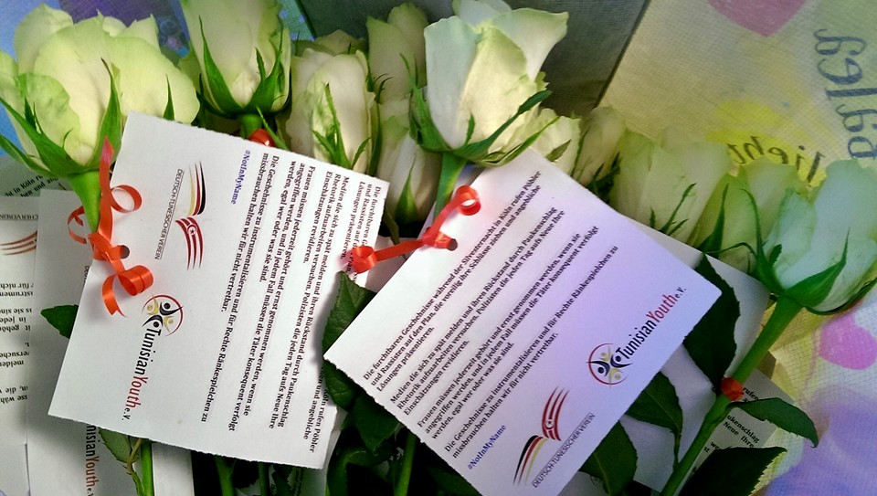 Tunesische Jugendliche verteilen Rosen am Kölner Hauptbahnhof