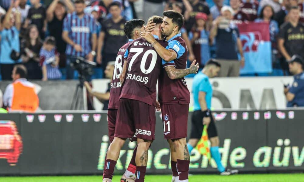 Trabzon: Ozan Tufan gratuliert Denis Draguş nach dessen Tor. Beide Spieler umarmen sich freudig, während die Fans im Hintergrund jubeln.